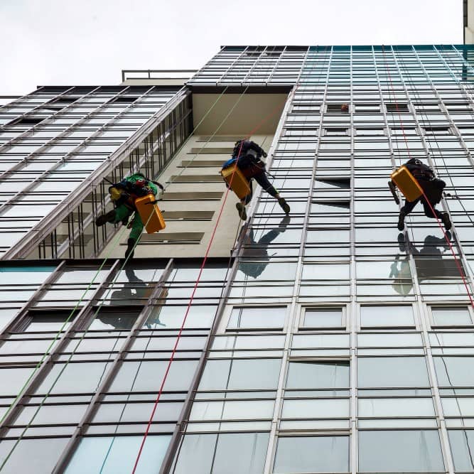 industrial-mountaineering-workers-hangs-residential-facade-building-while-washing-exterior-facade-glazing-rope-access-laborers-hangs-wall-house-concept-industry-urban-works-copy-space (1)